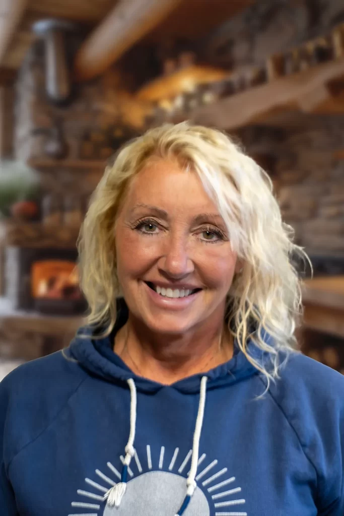 Julie Nelson, Herbalist, preparing natural herbal remedies in a cozy cabin kitchen.